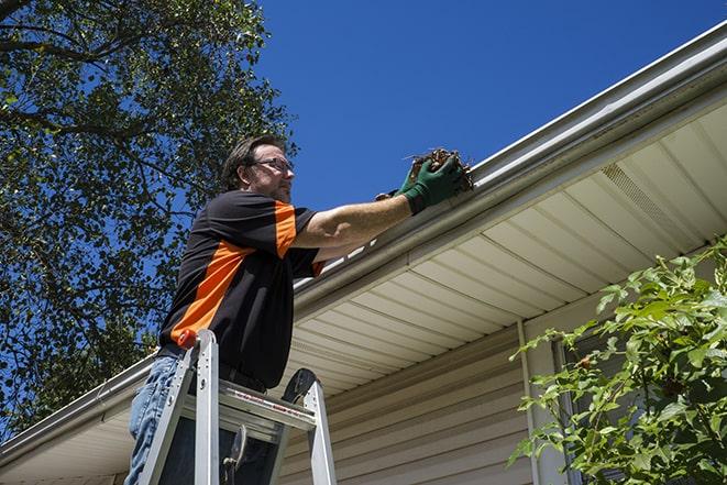 a maintenance worker fixing a leaking gutter in Brambleton, VA